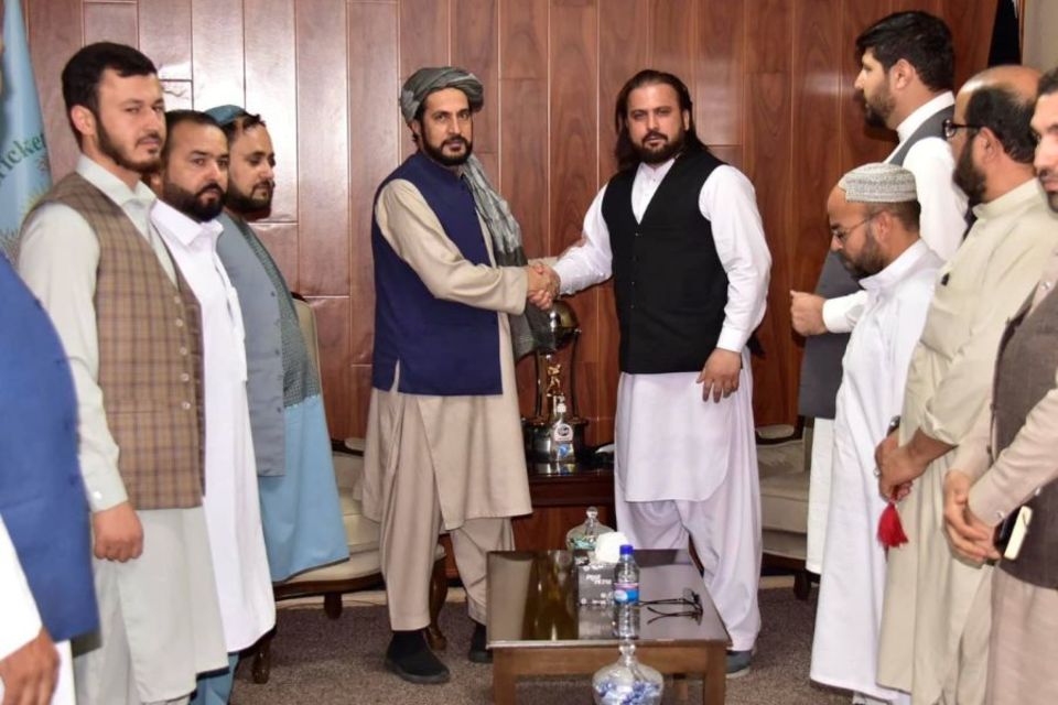 New ACB chairman Azizullah Fazli (left) shakes hands with CEO Hamid Shinwari