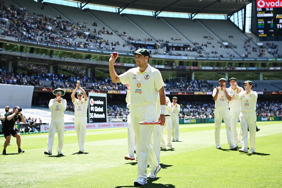 Scott Boland walks off with the match ball held aloft