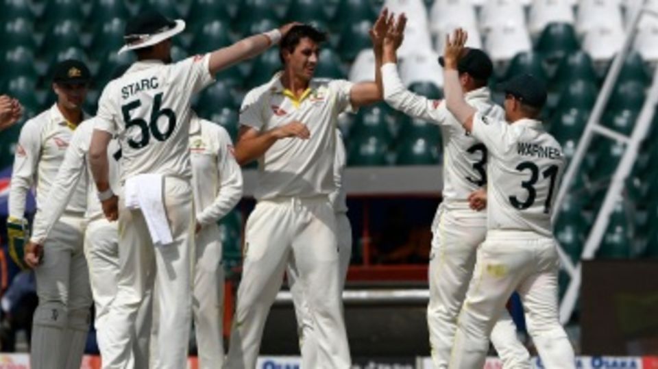 Pat Cummins celebrates with team-mates after dismissing Fawad Alam