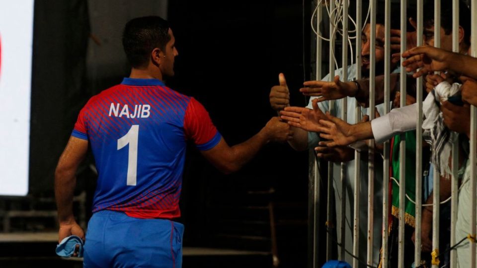 Najibullah Zadran shakes hands with fans after finishing the game
