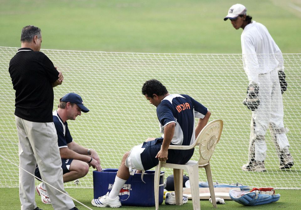 Indian team physio John Gloster helps Sachin Tendulkar tend to an ankle injury with an ersatz ice bucket
