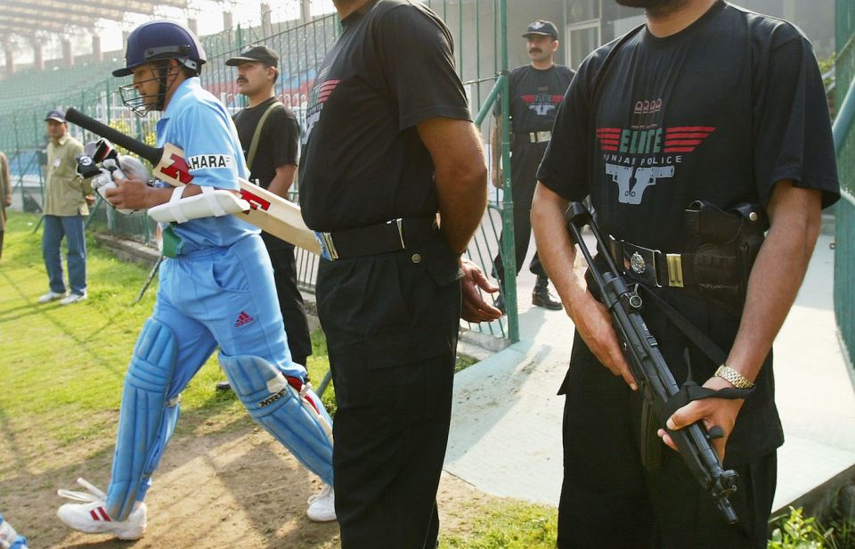 Sachin Tendulkar walks out to bat from among what seems like a battalion of security men