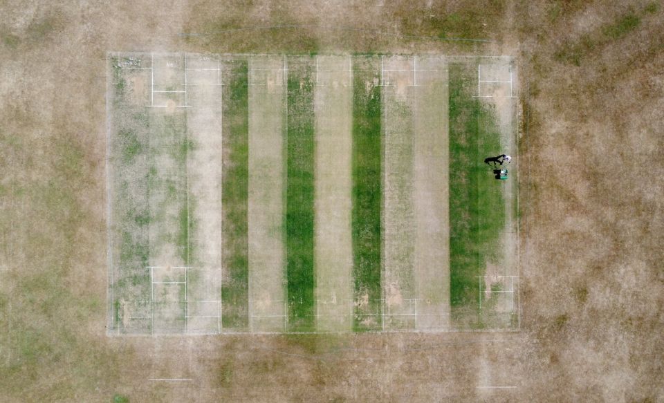 How green is your alley: a groundsman in Kent prepares pitches for matches in July 2022