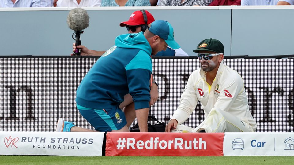 Nathan Lyon sits off the field injured