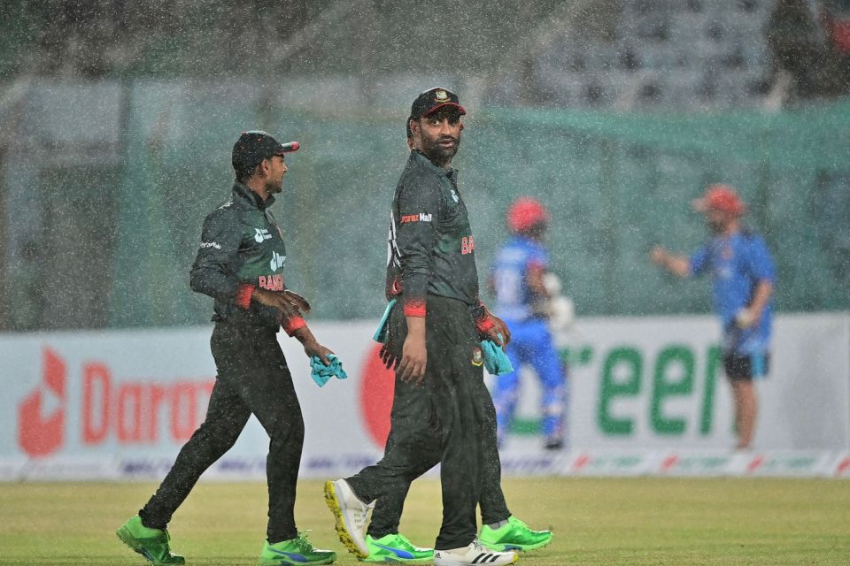 Tamim Iqbal leaves the field with his team-mates as the rain sets in