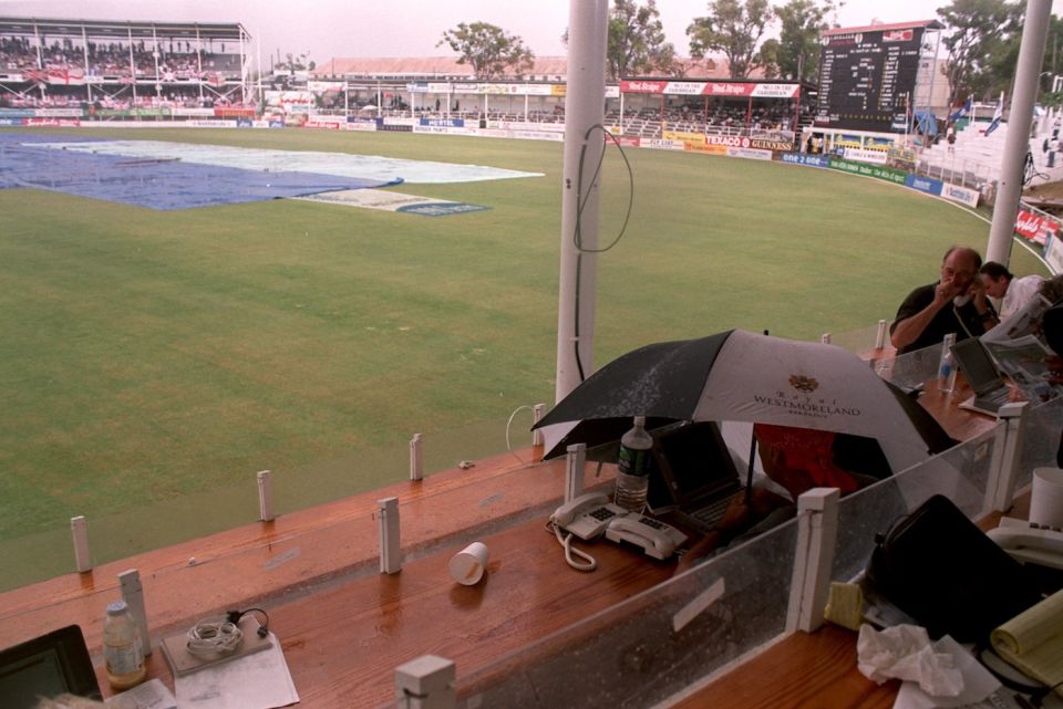 A journalist makes heavy weather of writing during a rain delay in Antigua