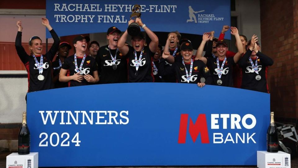 Grace Scrivens holds the 2024 Rachael Heyhoe Flint Trophy aloft