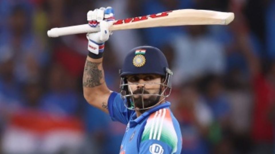 Virat Kohli raises his bat after getting to his half-century