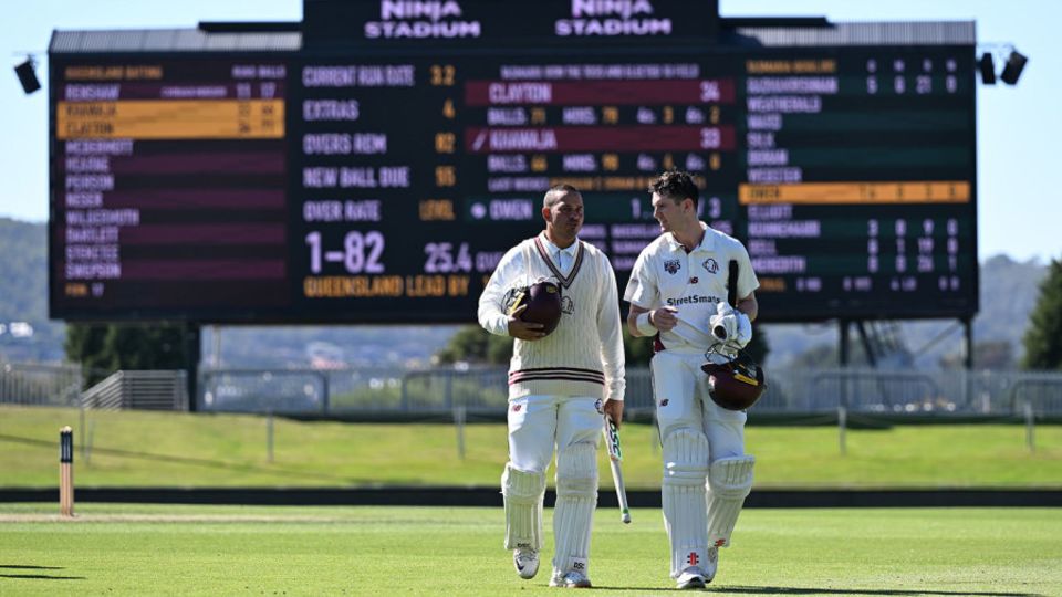 Usman Khawaja and Jack Clayton walk off after completing victory