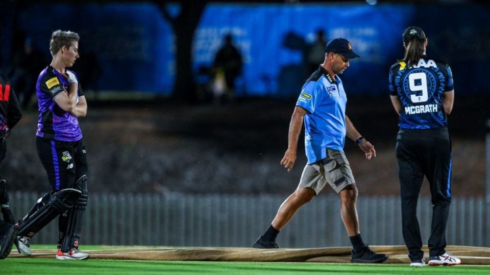 Elyse Villani and Tahlia McGrath inspect the pitch with groundsman Trent Kelly