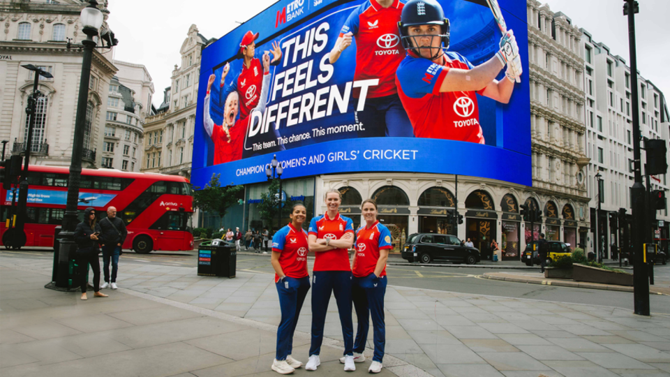 Sophia Dunkley, Lauren Bell and Nat Sciver-Brunt in front of the screen at Piccadilly Lights