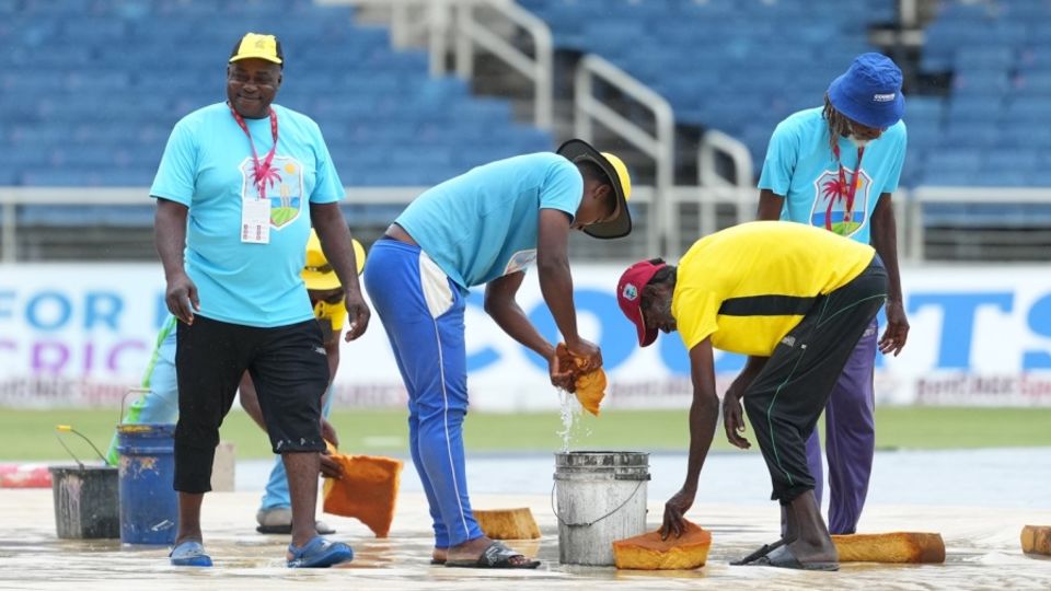 The Sabina Park staff clear the water on the ground