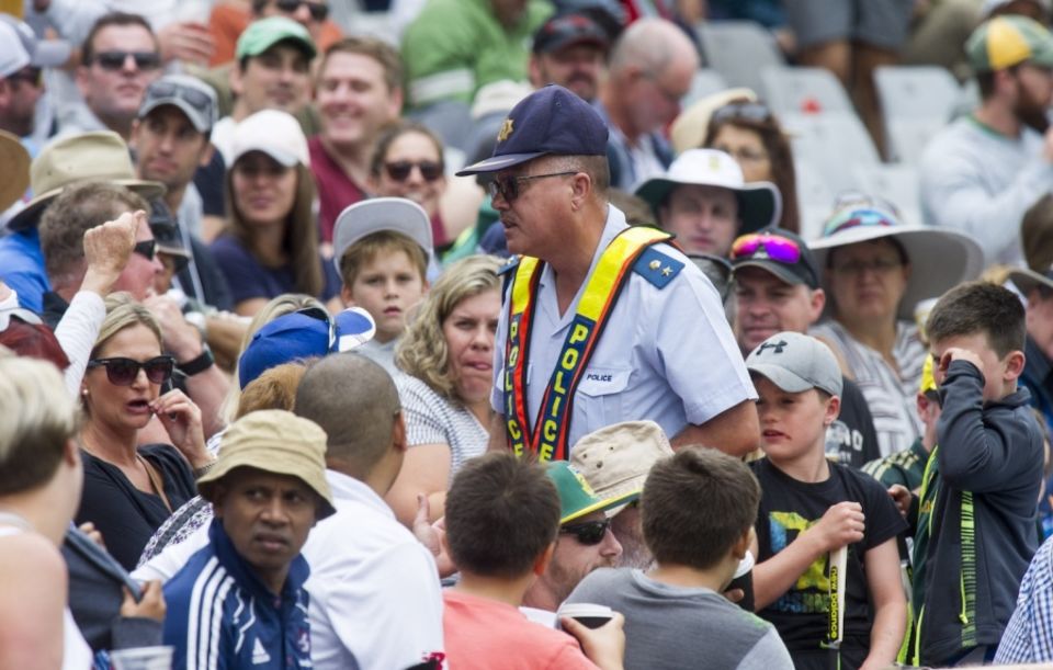 A policeman confronts spectators chirping at Warner in Cape Town