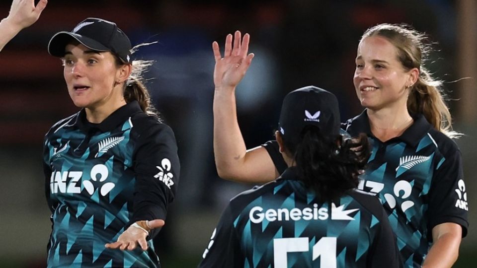 Melie Kerr and Jess Kerr celebrate a wicket with their team-mates