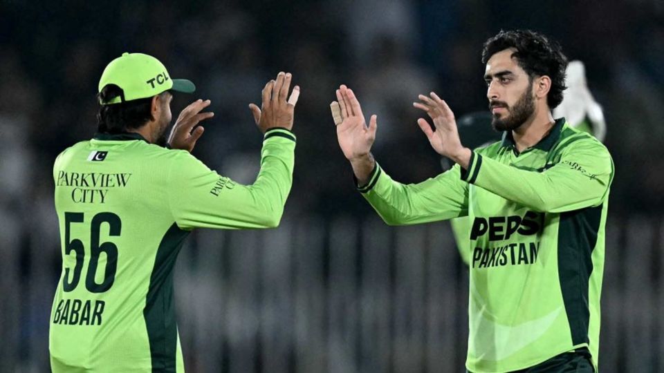 Minhas celebrates with Babar Azam after taking the wicket of Tom Banton