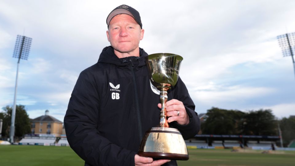 Gareth Batty, Surrey's head coach, poses with the County Championship trophy