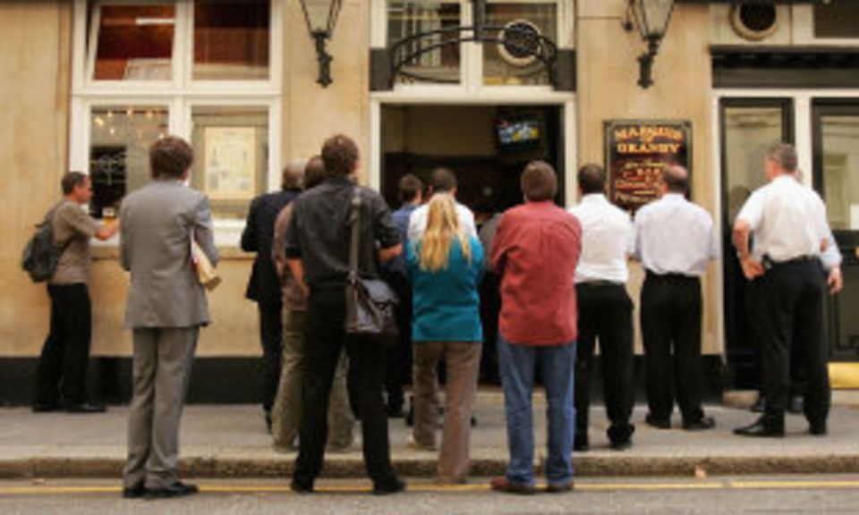 People crowd around a pub to catch a glimpse of the Ashes