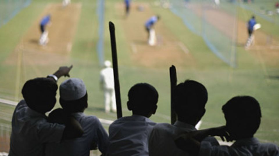 A group of schoolchildren watch India bat in the nets