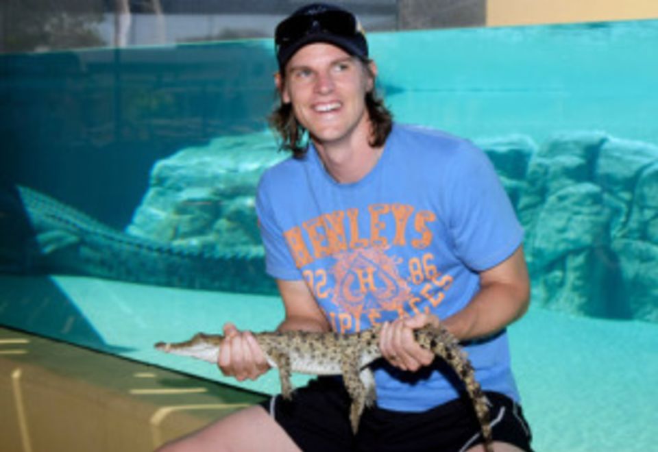 Nathan Bracken shows off his prize for Best Performance While Wearing A Headband, a live crocodile