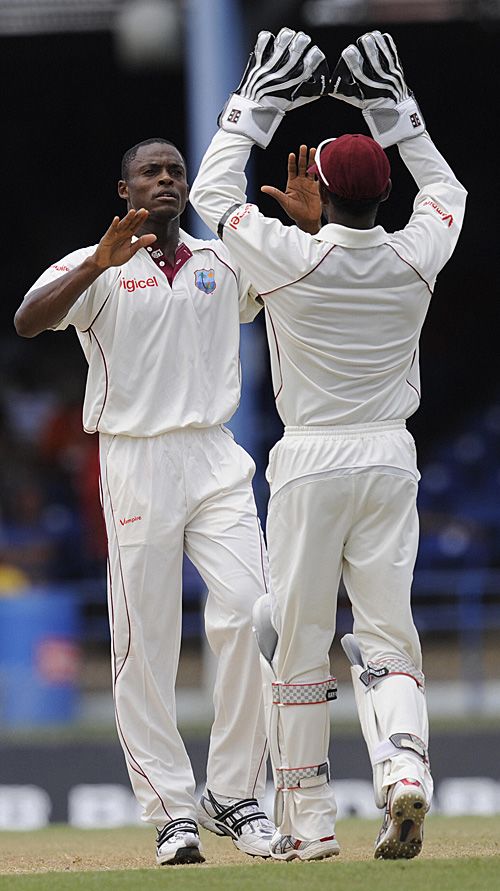 Denesh Ramdin congratulates Daren Powell on the wicket of Alastair Cook