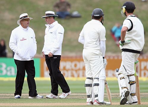 The umpires look concerned about the light