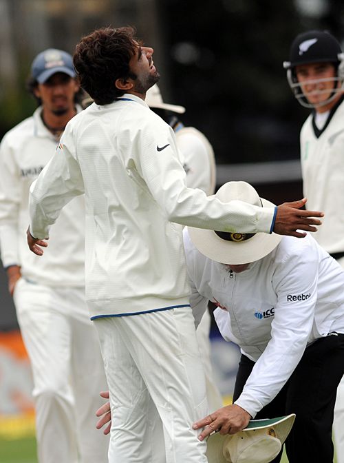 Umpire Daryl Harper searches Munaf Patel for the missing match ball