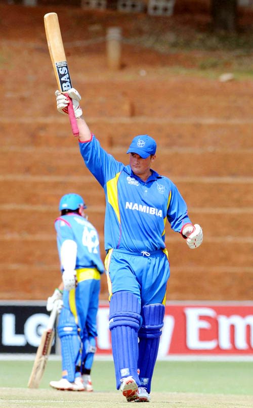 Jan-Berrie Burger raises his bat on reaching his century