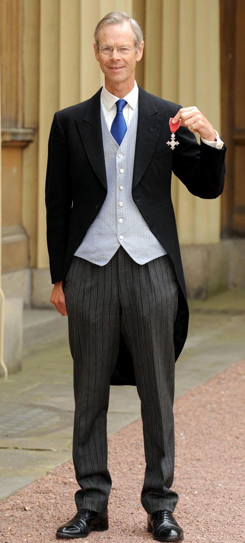 Christopher Martin-Jenkins poses outside Buckingham Palace after receiving his MBE