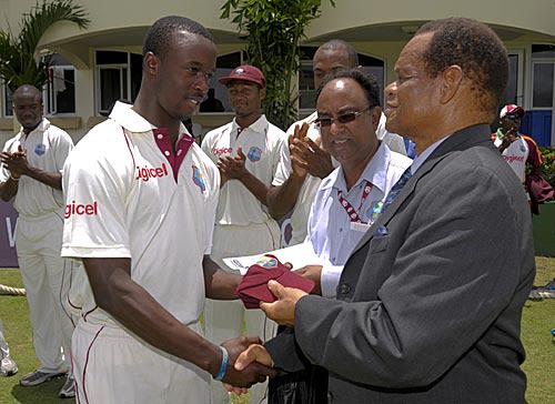 Kemar Roach receives his Test cap from WICB President Julian Hunte