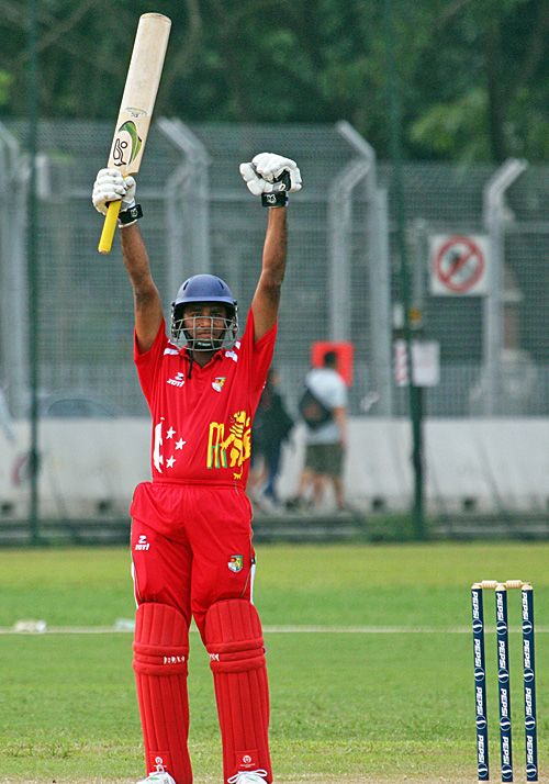 Buddikha Mendis raises his bat to salute his match-winning century against Bahrain