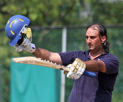 Zaheer Ashiq raises the bat after reaching his half-century
