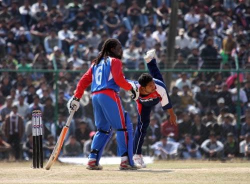 Basanta Regmi bowls as Carl Wright looks on