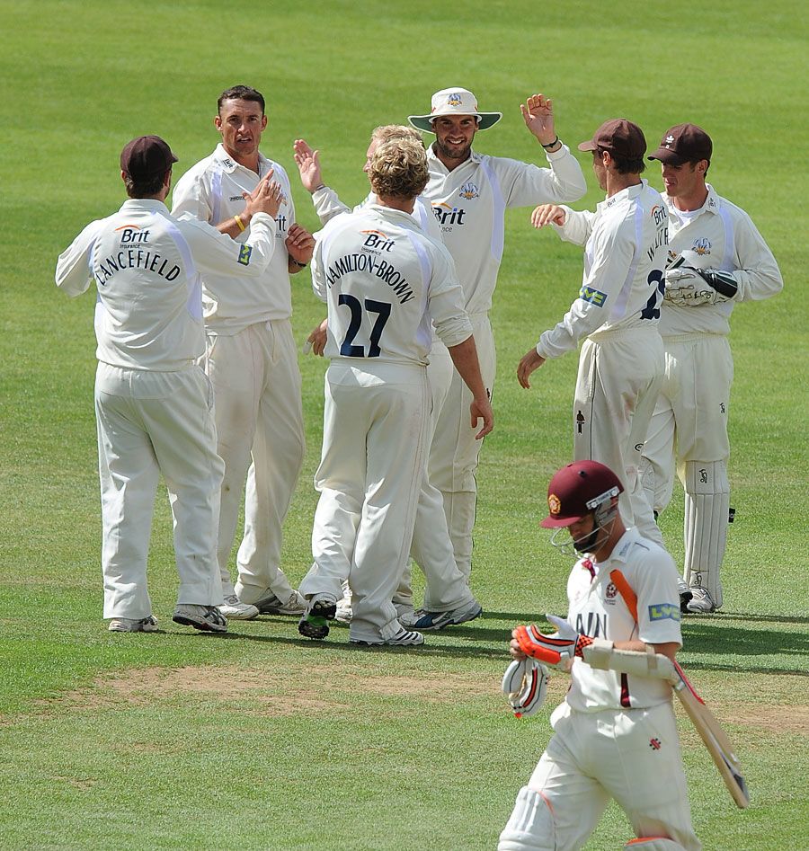 Andre Nel is congratulated by his Surrey team-mates after removing Stephen Peters