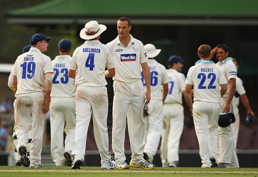 Stuart Clark and his team-mates gather after a wicket