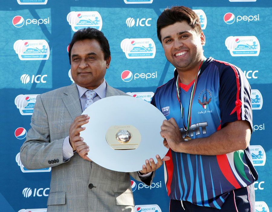 Hisham Mirza receives the WCL Division Eight trophy from ICC board director Mustafa Kamal