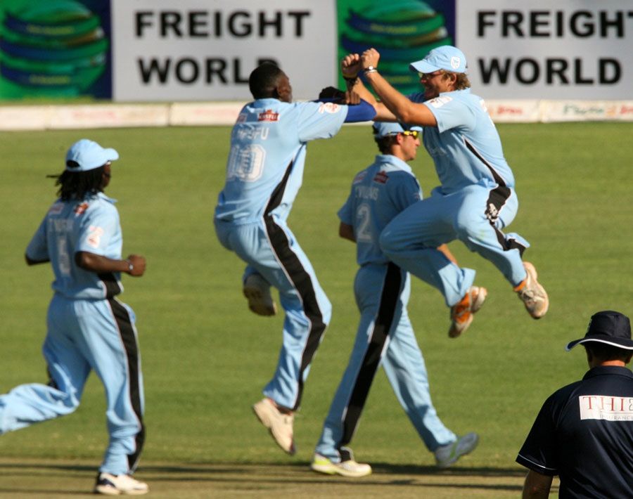 Chris Mpofu and Gavin Ewing celebrate as another wicket falls