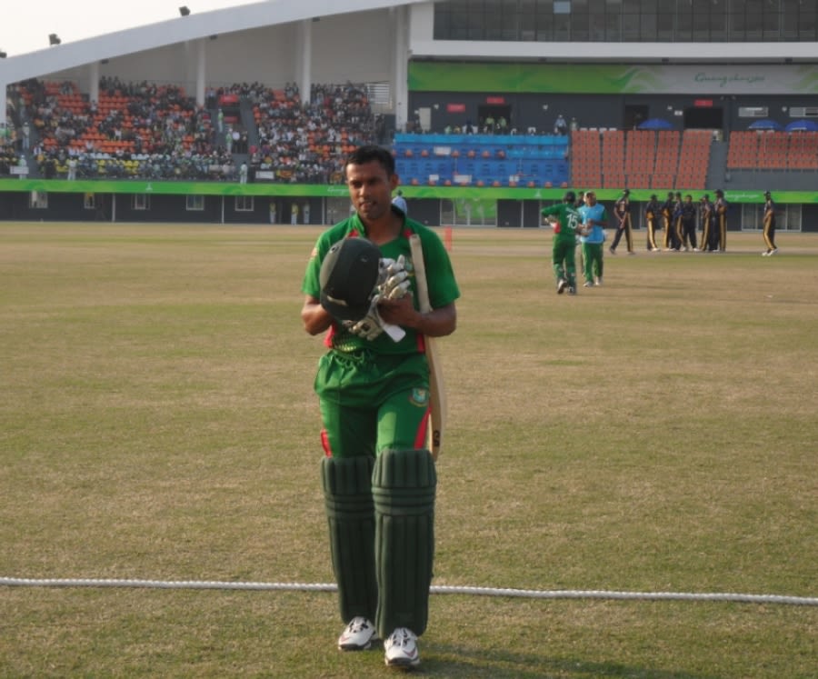 Faisal Hossain, Bangladesh's top scorer, leaves the field after being dismissed for 33