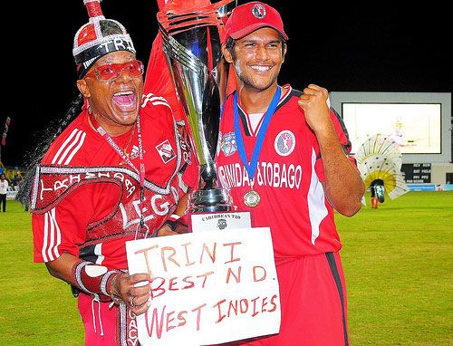 Daren Ganga poses with the trophy alongside a Trinidad fan