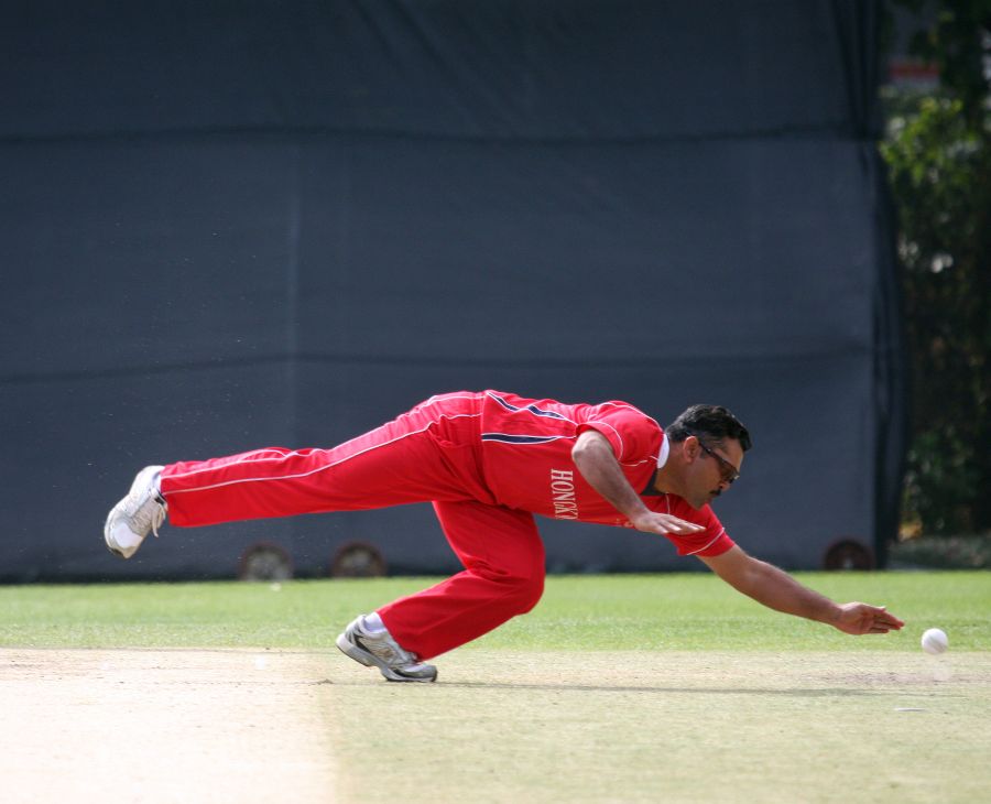 Munir Dar dives to field the ball off his own bowling during his parsimonious spell