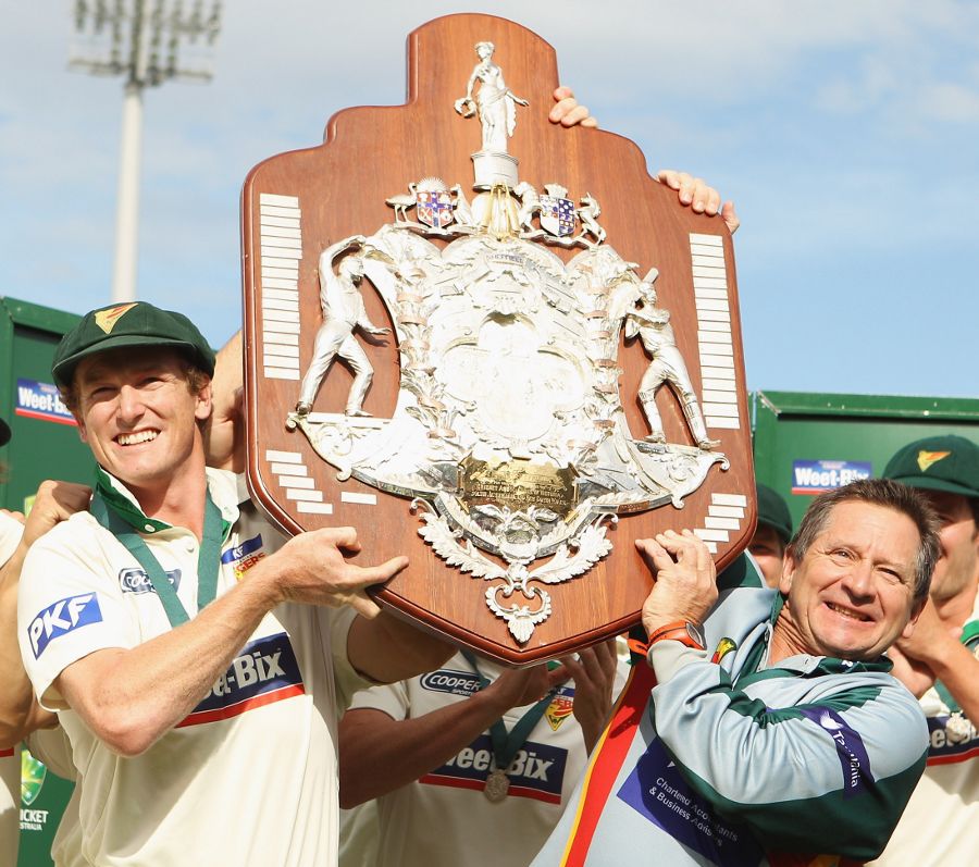 Victorious Tasmania captain George Bailey and coach Tim Coyle hold the Sheffield Shield aloft