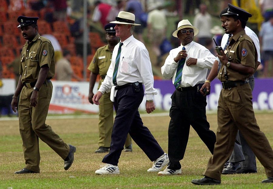 Rudi Koertzen and BC Cooray are escorted off the field by security officials after another wretched day for both of them