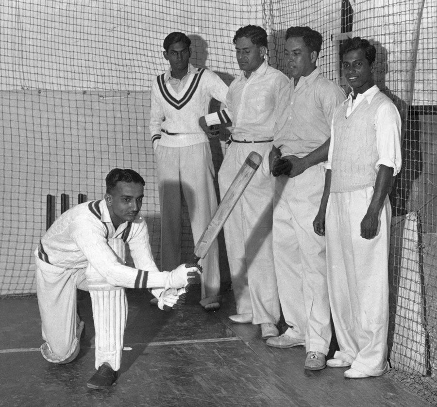Vijay Merchant bats in the indoor nets of the Alan Fairfax Cricket School as his team-mates look on