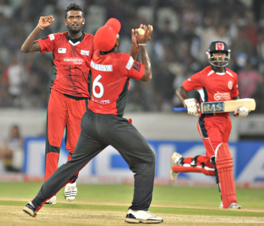 Arosh Janoda looks on as Mahela Udawatte holds a catch