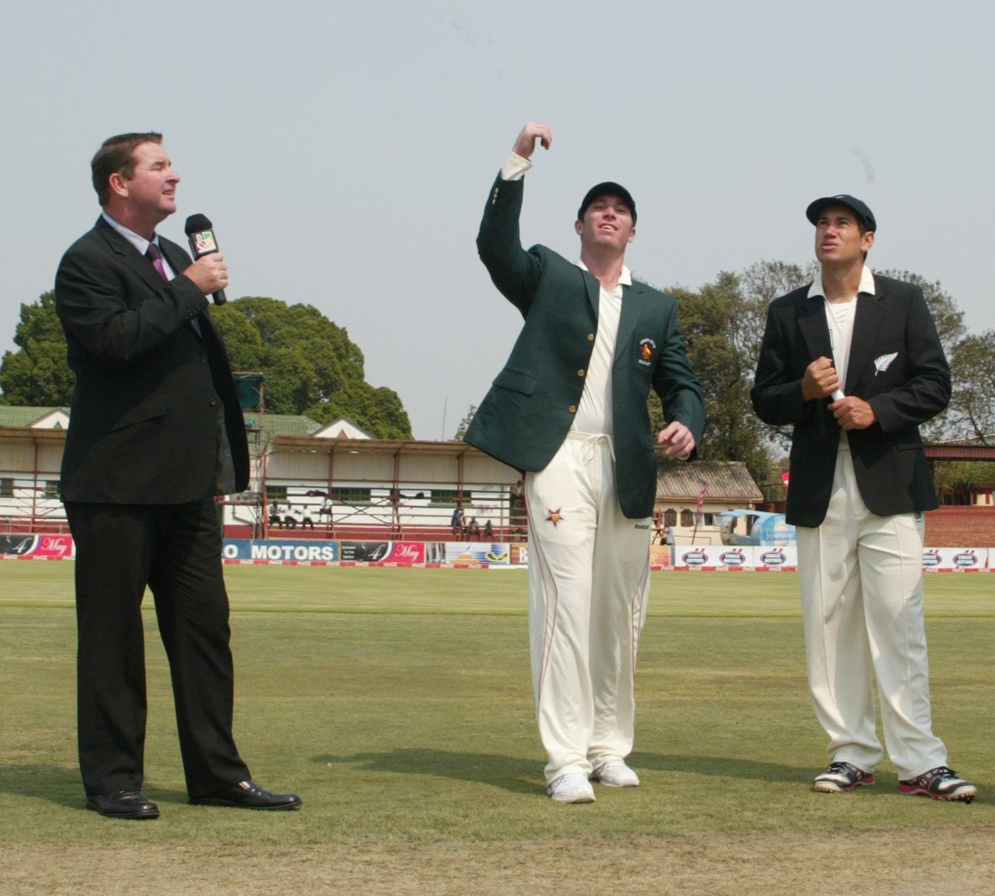Brendan Taylor spins the coin at the toss as Ross Taylor and Alistair Campbell look on