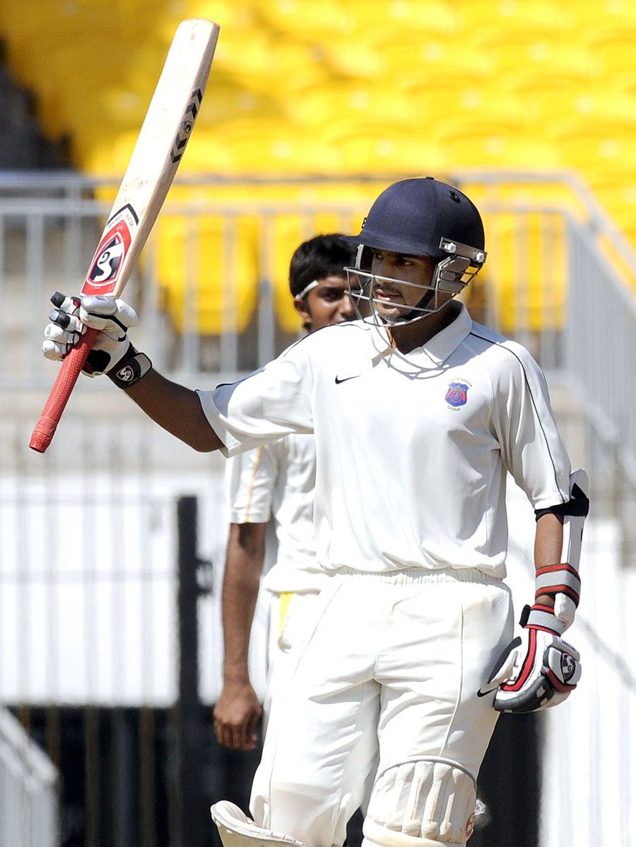 Harshad Khadiwale raises his bat after reaching his hundred