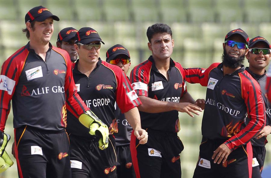 Yasir Arafat is congratulated by his team-mates on his three first-over scalps