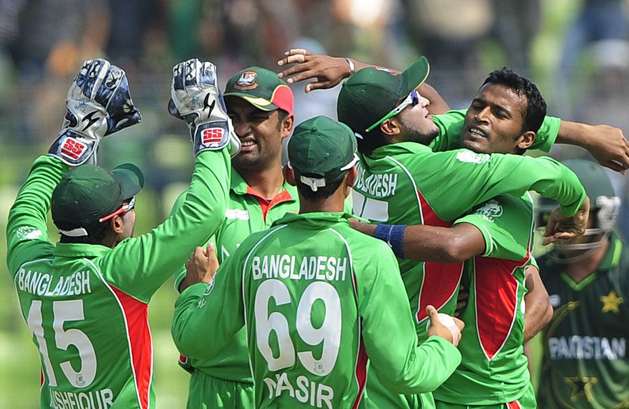 Bangladesh players crowd Nazmul Hossain after taking a wicket