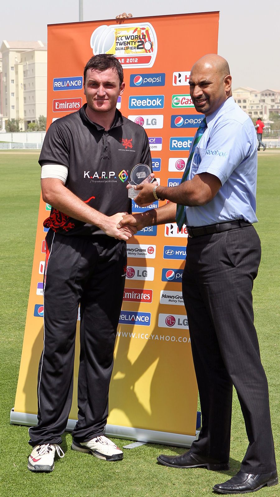 Jamie Atkinson receives his Man of the Match award from Tournament Official Graeme Labrooy