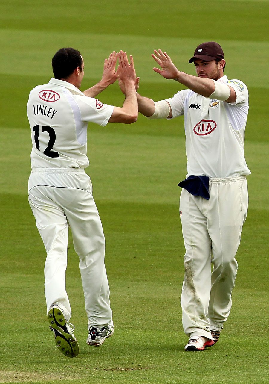 Tim Linley celebrates a wicket with team-mate Tom Maynard