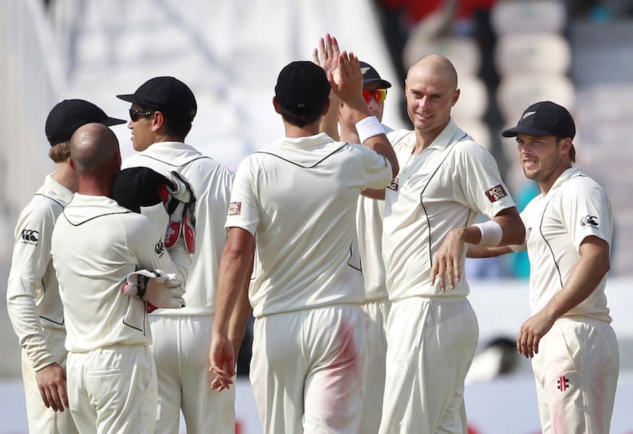 Chris Martin being congratulated by team-mates after picking up Virat Kohli